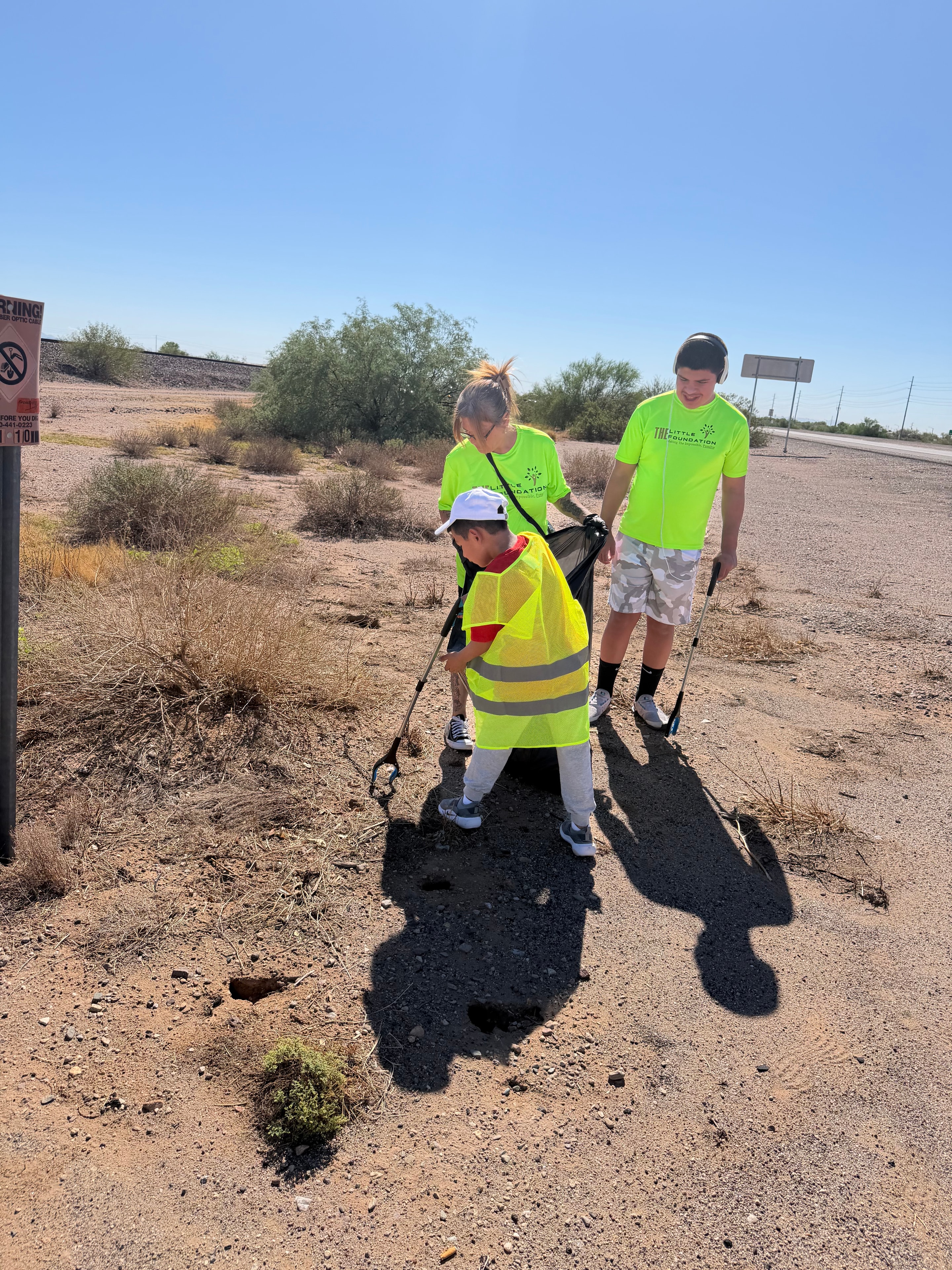 Young volunteer with litter grabber smiling during National Clean Up Day